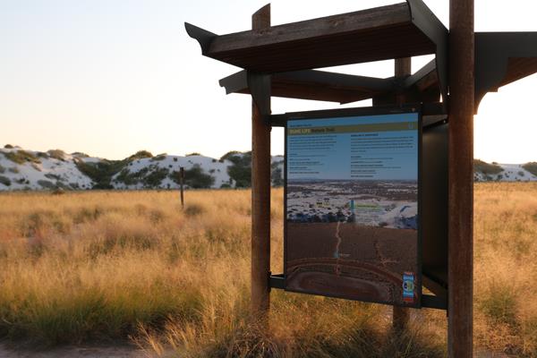 The Dune Life Nature Trail kiosk panel at sunset.
