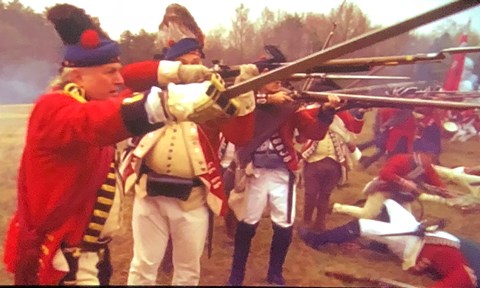 Reenactors portraying Scottish Highlander soldiers raise swords and muskets for battle.