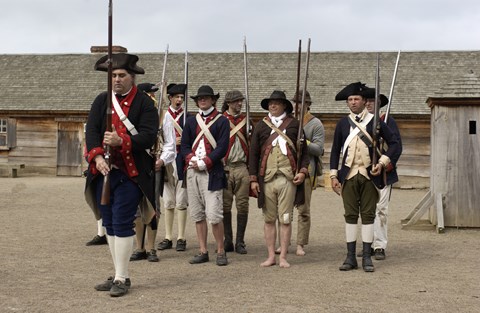 A small company of about 24 soldiers stand in formation. They all have different uniforms.
