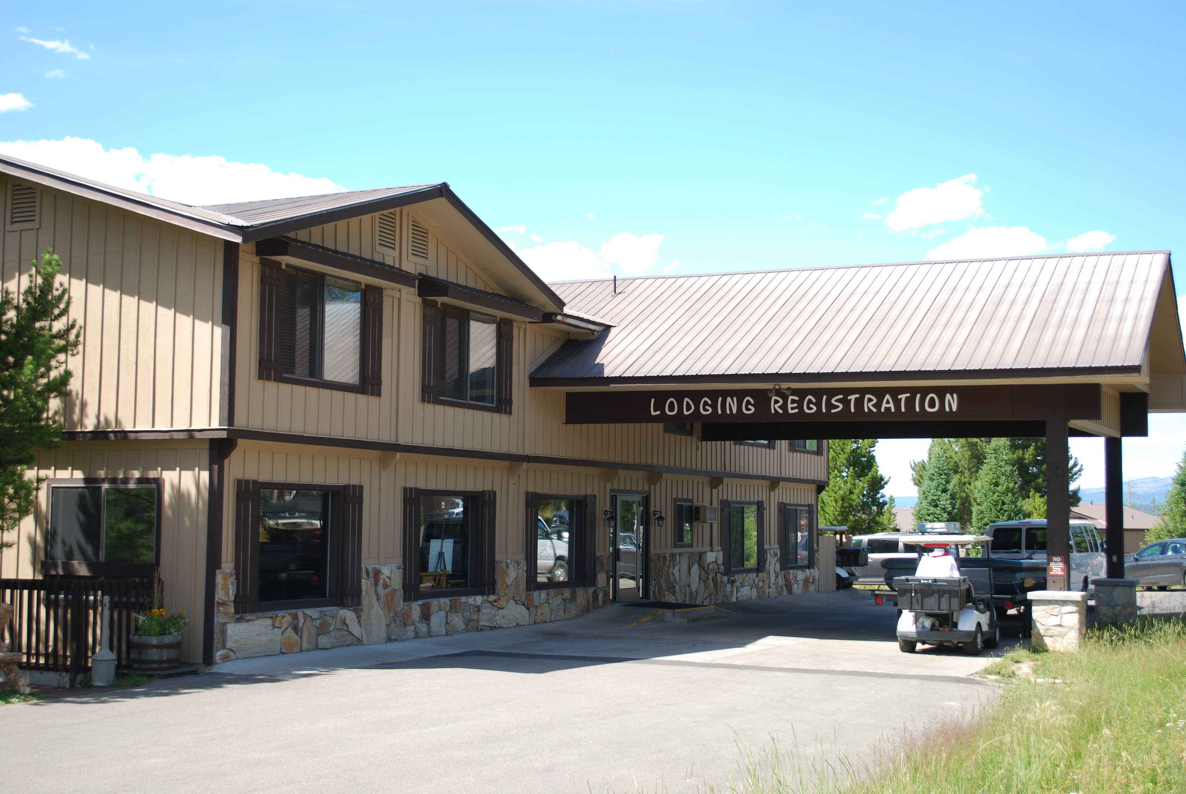 Modern wood and stone clad building with drive under overhang.