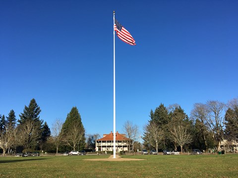 The American flag flies on the Parade Ground flagstaff on a sunny day.
