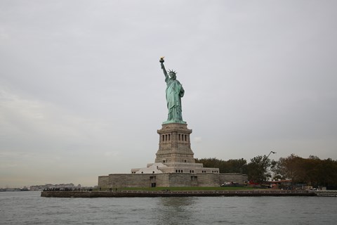 A view of the Statue of Liberty and Liberty Island from the water.