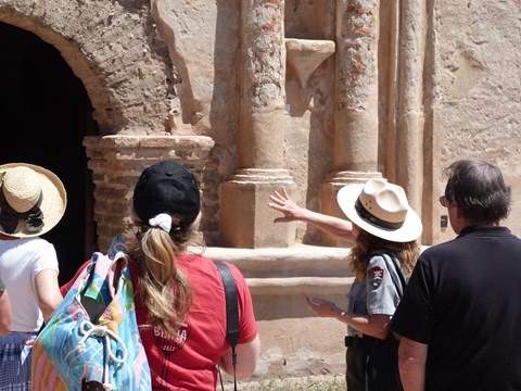 ranger pointing to front of church, visitors listening