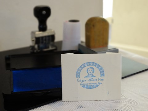Color image featuring a piece of white paper with an Edgar Allan Poe stamp.