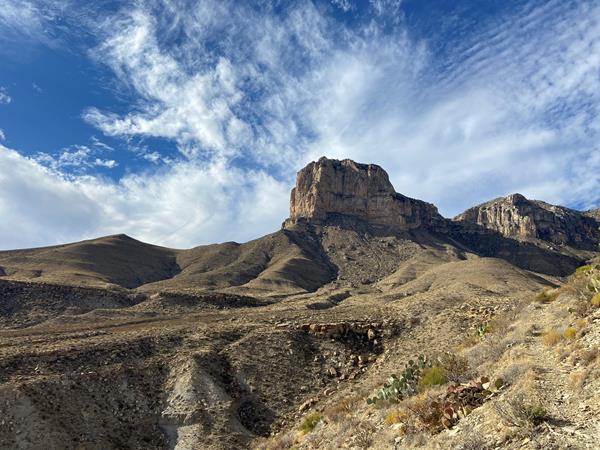 A tall promontory point rises above a desert landscape