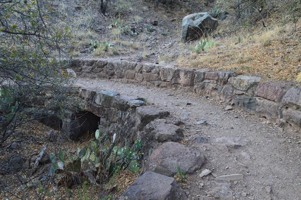 A dirt hiking trail crosses over a culvert built from local stone by the Civilian Conservation Corps
