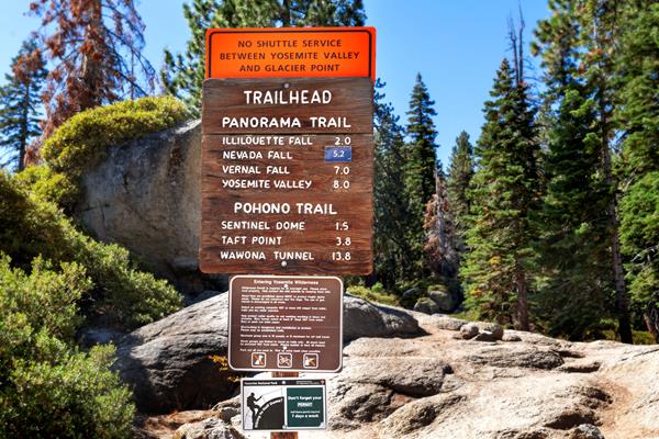 Wooden and metal signs at the trailhead