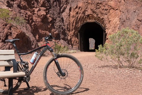A bike sits on a path overlooking a lake