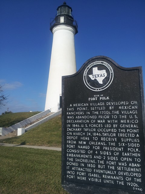 White lighthouse with State of Texas historical marker in the foreground.