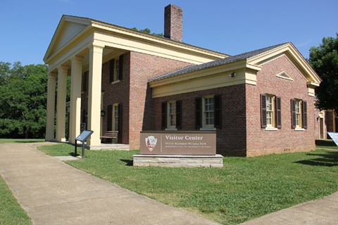 A large brick building with yellow columns.