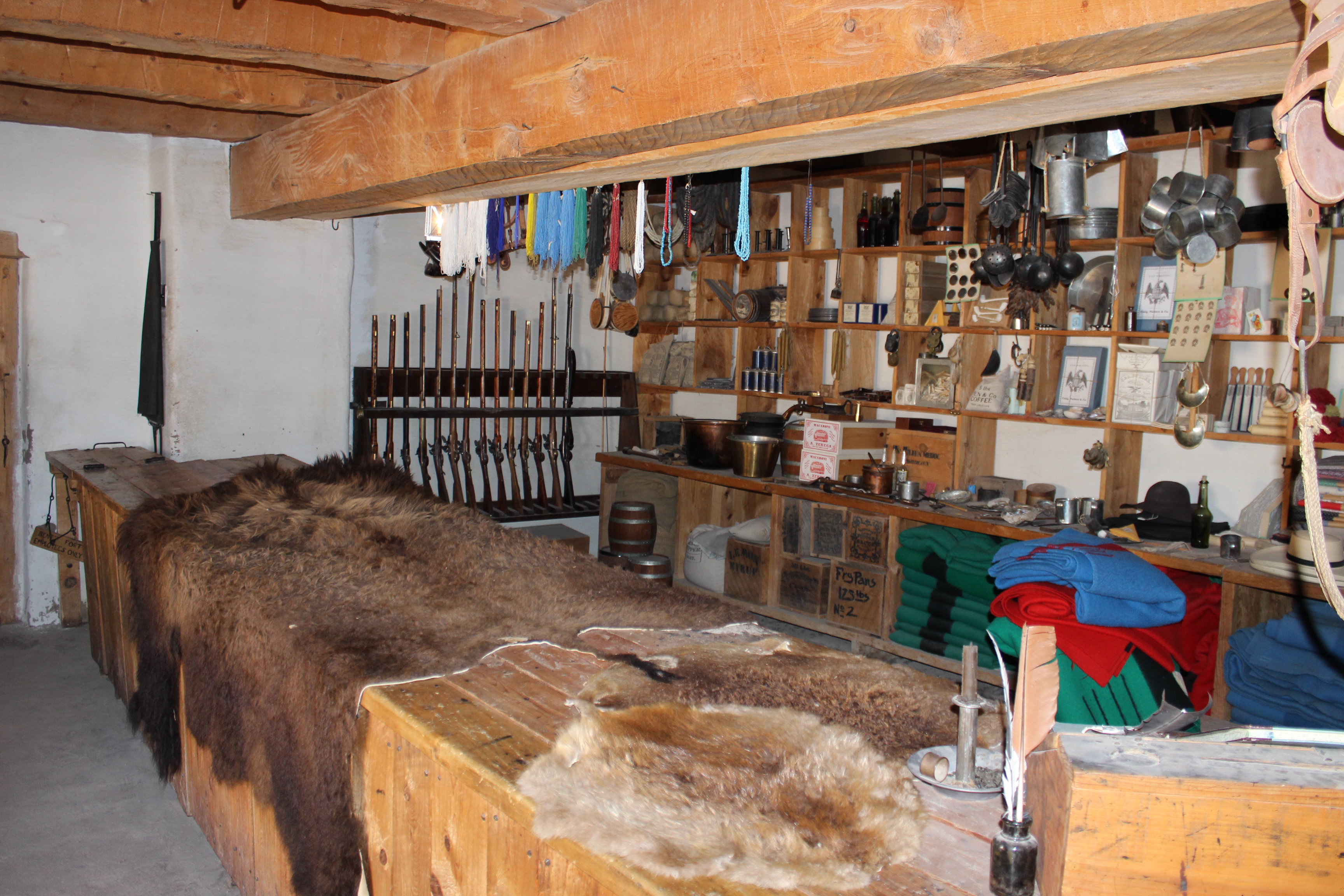 Trade Room at Bent's Fort with various trade items including animal hides, guns, blankets, etc.