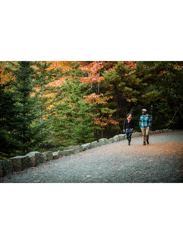 Two people walking along a crushed gravel surfaced road