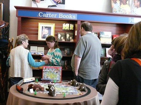 a woman assists a young girl and a man in the bookstore at Jimmy Carter NHP