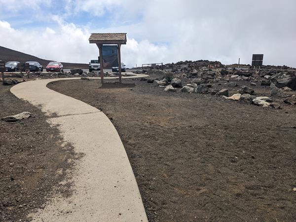 cement trail through cinder to a trail sign