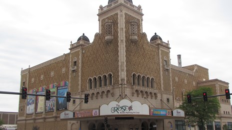 Corner theater building with large Moorish tower. Entrance located at corner of building.