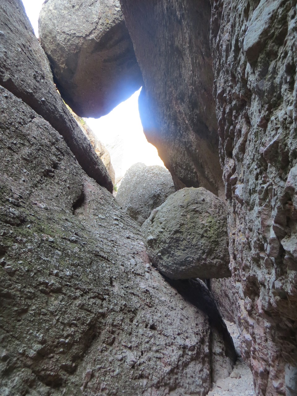 Narrow rock passage in Balconies Cave with daylight visible through an opening above.