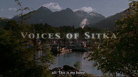 Movie title and text "this is my home" with boats in a harbor and mountains in the background