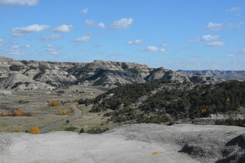 A road winds past buttes, viewed from above.