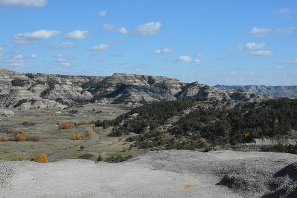 A road winds past buttes, viewed from above.