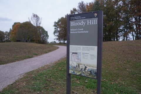 Bloody Hill Hiking Trail with wayside sign giving information about Bloody Hill.