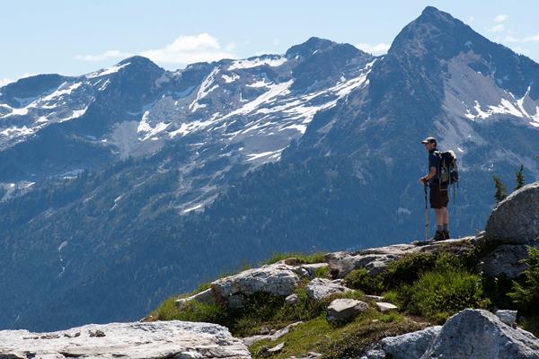 A hiker stands looking at a scenic mountain view.