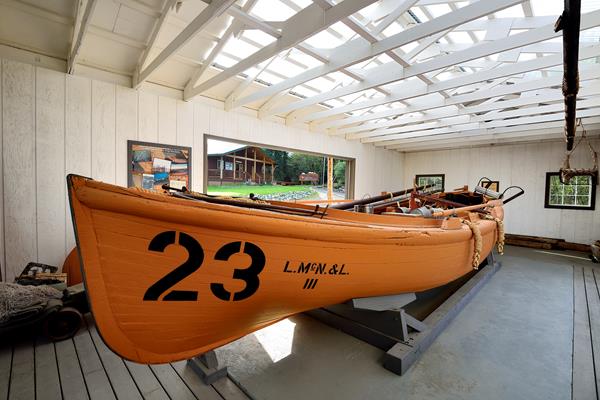 A large wooden boat sits with the number 23 painted on it.