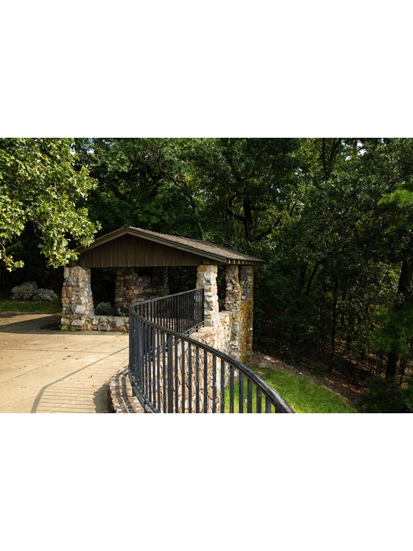 A stone shelter sits on a hillside overlooking a rolling landscape.