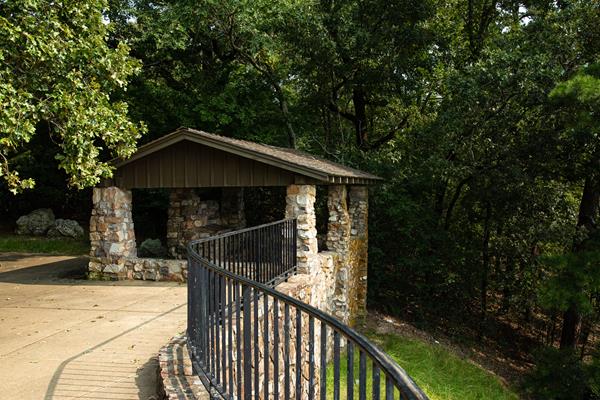 A stone shelter sits on a hillside overlooking a rolling landscape.