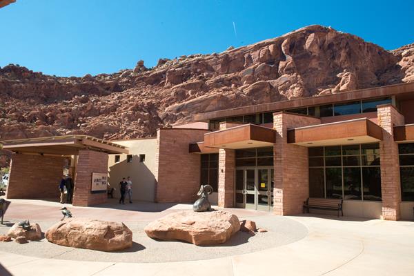 a red stone building with sculptures of animals in front