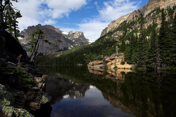 a mountain top is reflected in a lake