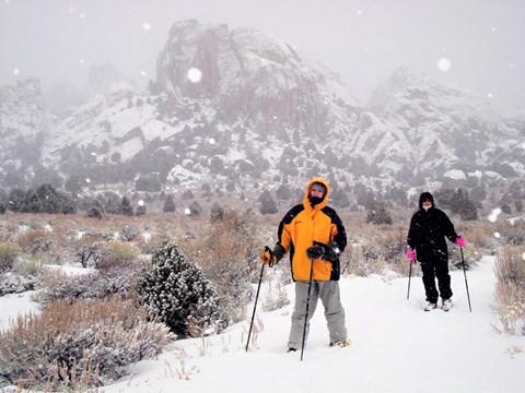 Two people snowshoeing during a snow storm in Castle Rocks