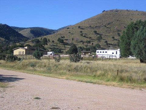 Horse corrals and camping trailers with desert hills rising behind.