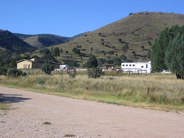 Horse corrals and camping trailers with desert hills rising behind.