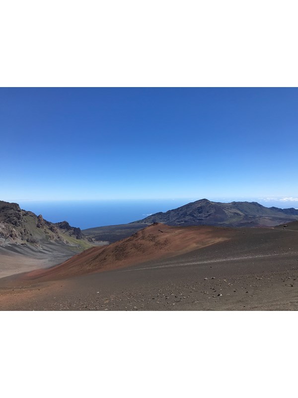 A trail leads down into a colorful volcanic valley.