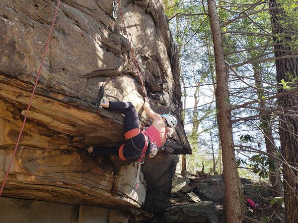 rock climber maneuvering around a small overhang