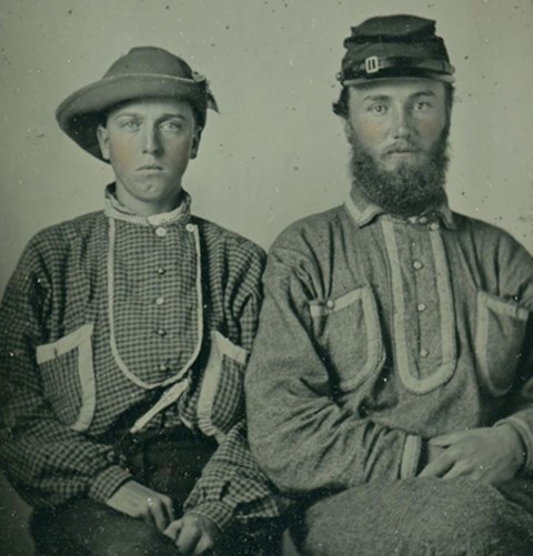 A historic photo shows two young men dressed in what appear to be homemade uniforms
