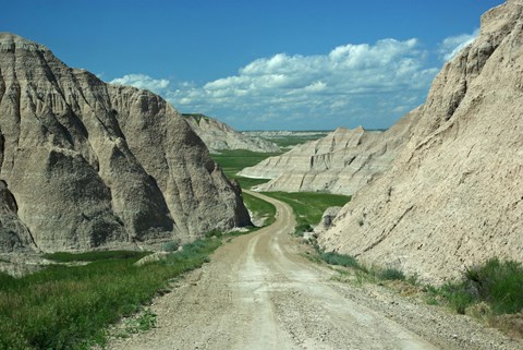a dirt road meanders through badlands buttes
