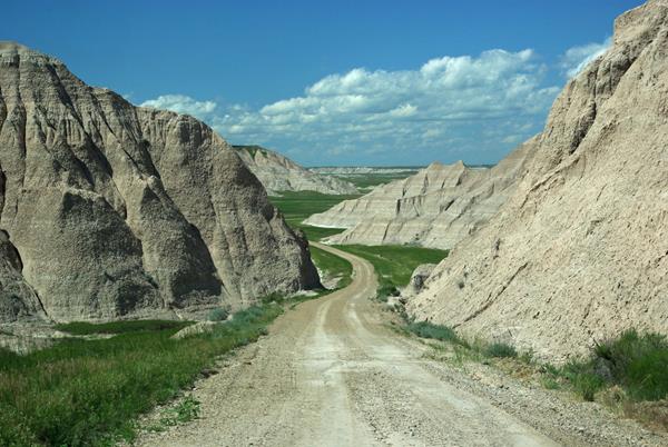 a dirt road meanders through badlands buttes