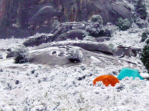 Two tents in the snow at a campsite in the City of Rocks.