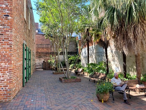 visitor sitting and reading a magazine in our courtyard