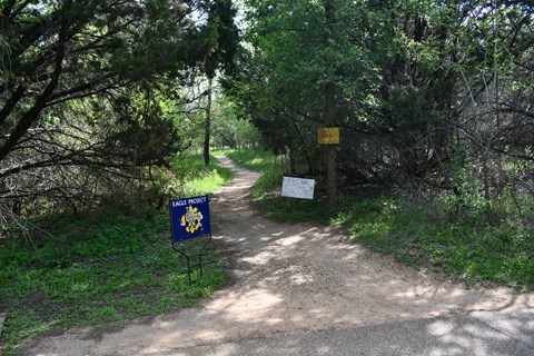 A sign with the Boy Scouts logo and the words "Eagle Project" stands at the start of a dirt trail.