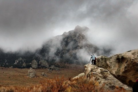 Photographers set up for a dramatic picture of storm clouds swirling around granite spires.