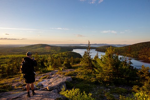Visitors photographs a sunset over a lake