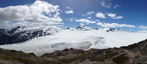 View of a glacier and icefield with mountains in the background.