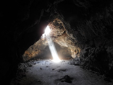 A beam of light shines into the lava tube