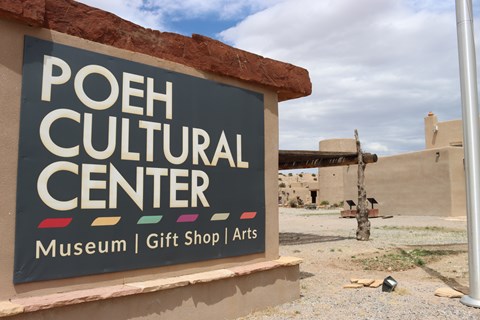 A large sign with white text on a black background, “POEH CULTURAL CENTER Museum | Gift Shop | Arts”