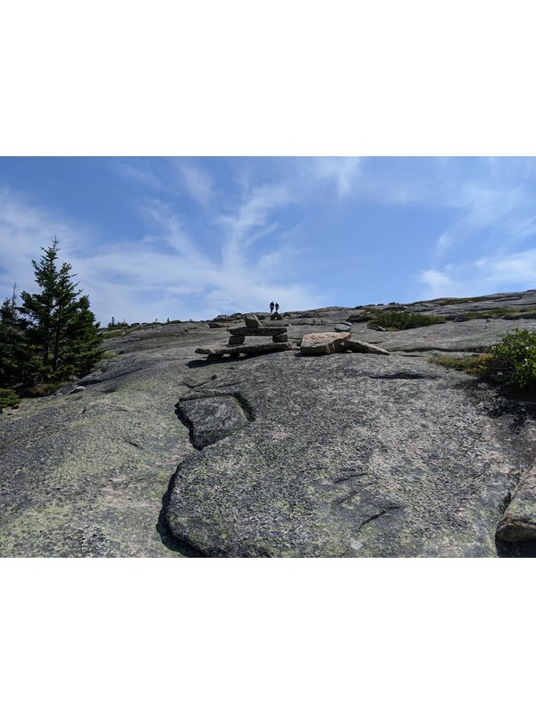 Rock cairns leading trail up exposed rock