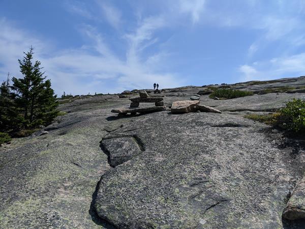 Rock cairns leading trail up exposed rock