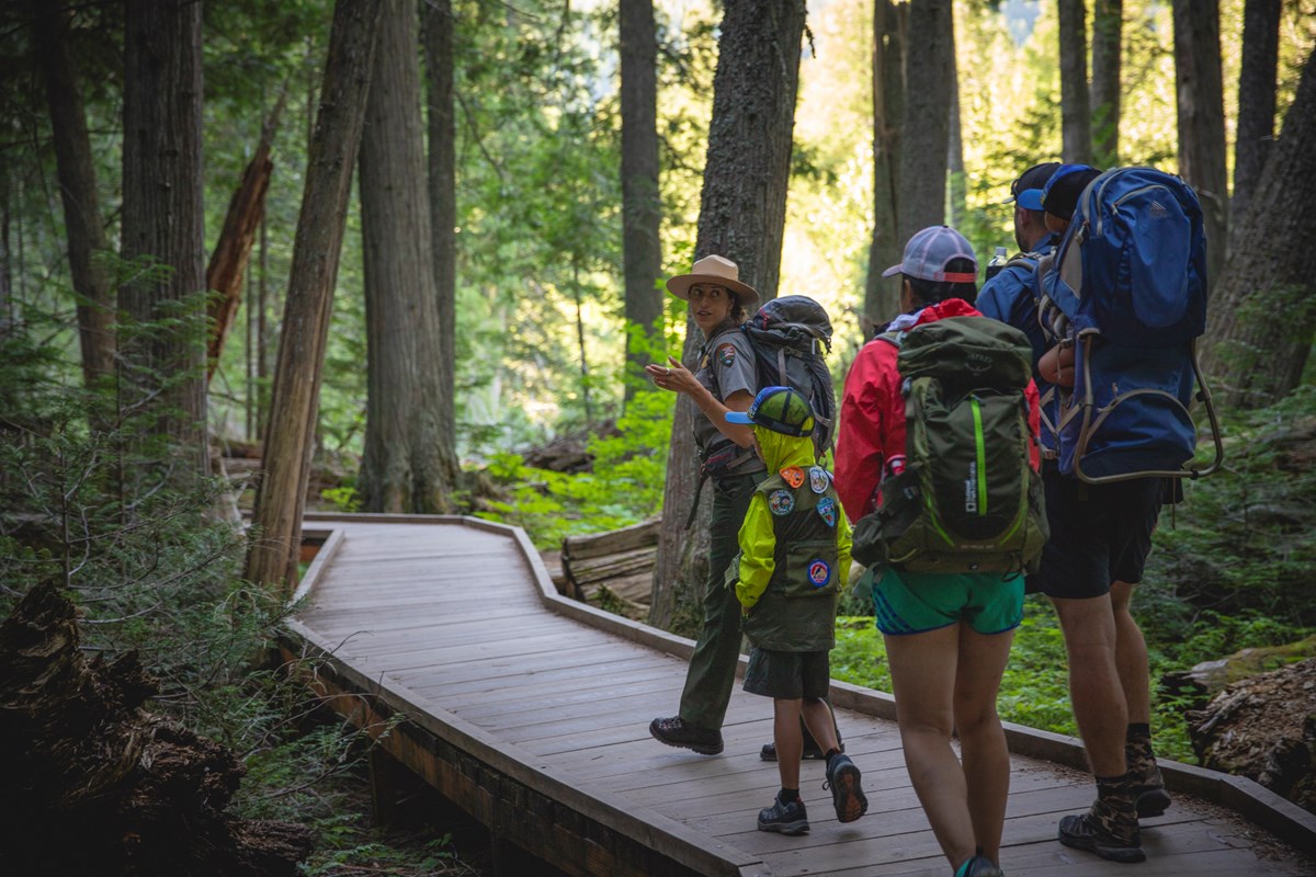A ranger leads a family on a boardwalk trail