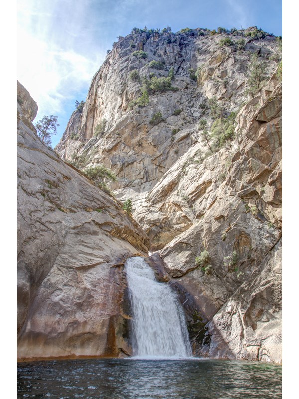 A large waterfall pumps water out into a pool.
